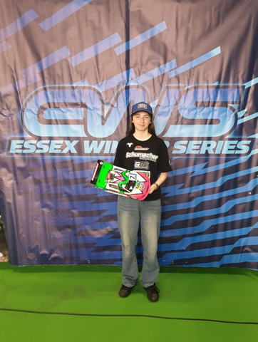 Emily holding a pink and green RC touring car in front of the Essex Winter Series banner.